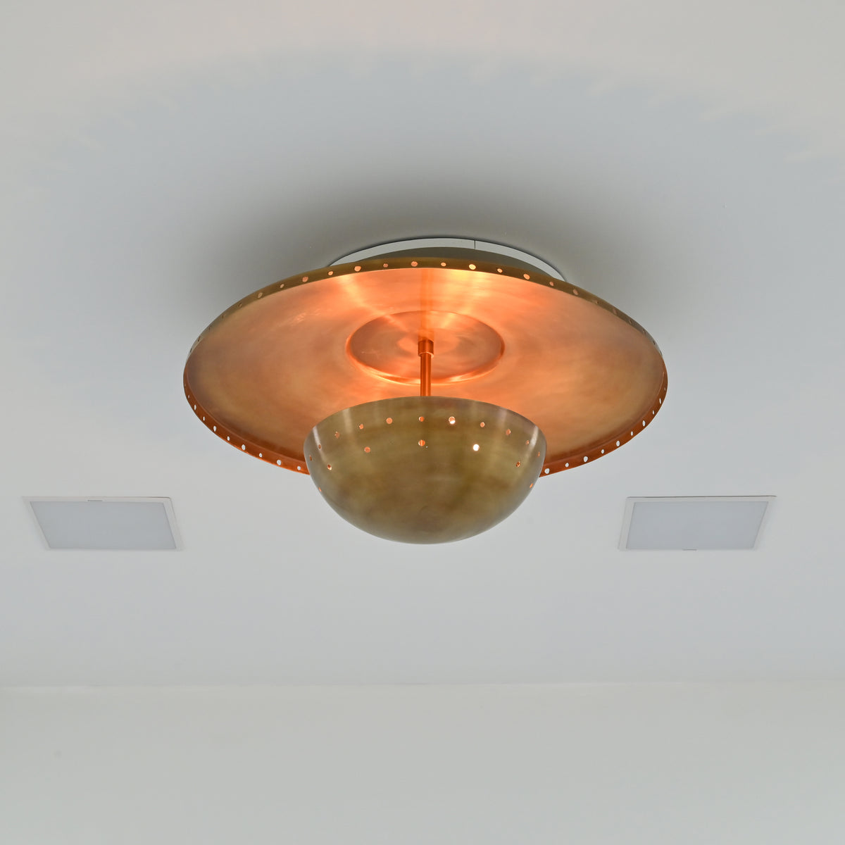 Brass patina ceiling fixture with broad shallow disc, central stem and perforated rounded bowl