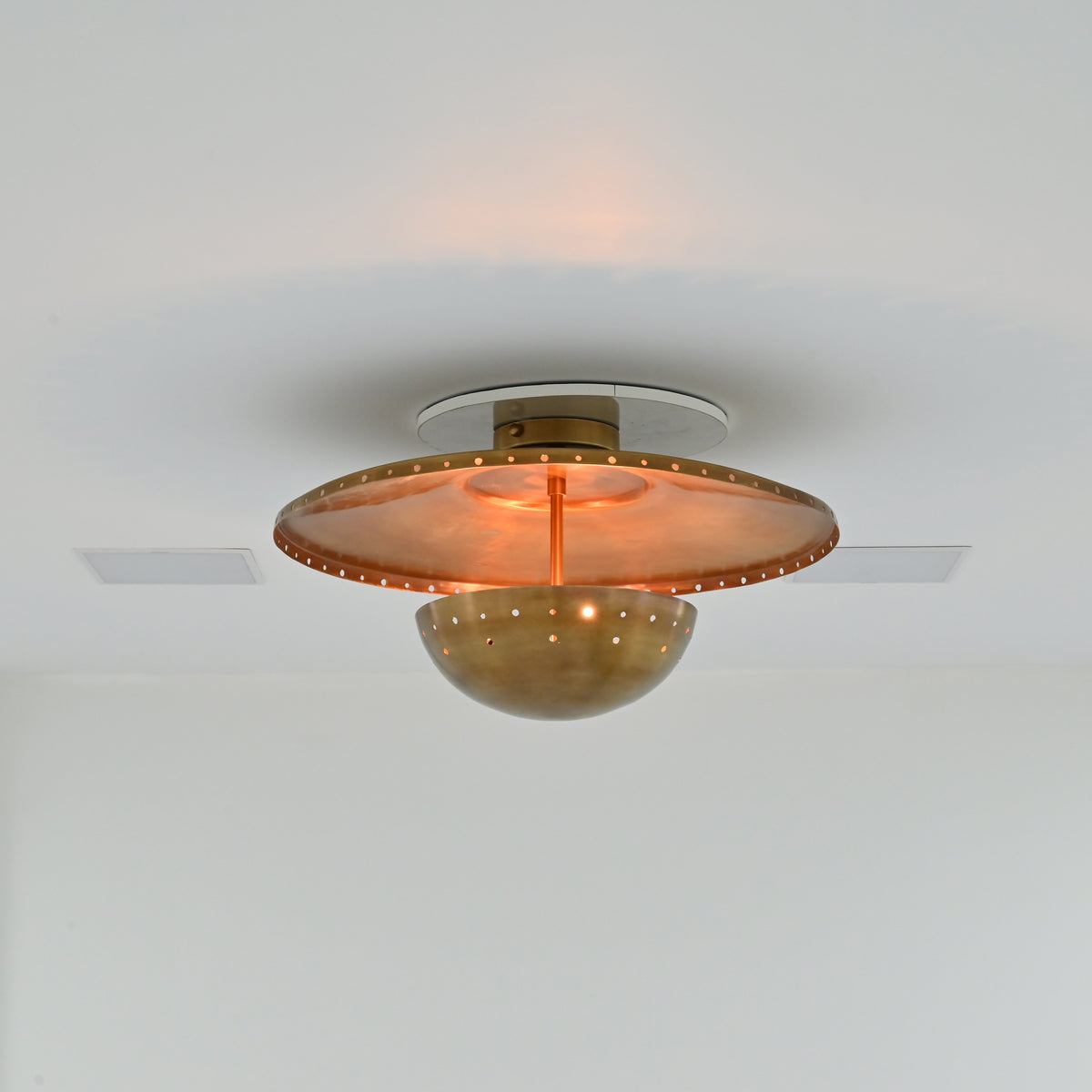 Statement brass ceiling light with perforated detailing and warm patina finish for modern interiors