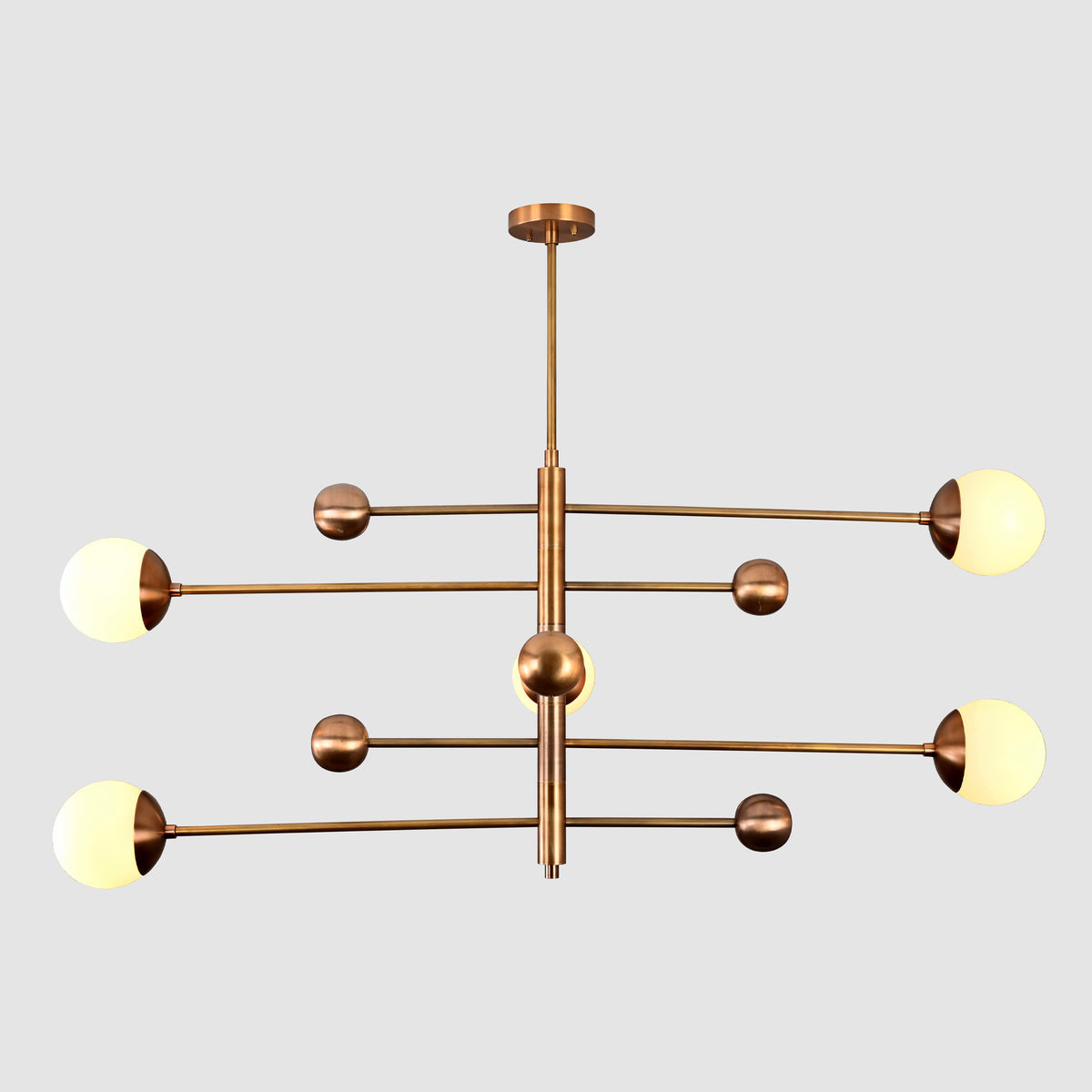 Opal glass globe chandelier close view showing warm glow, brass cup details, and decorative ball accents