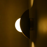 Opal glass globe wall sconce with crescent brass reflector for soft ambient lighting effect