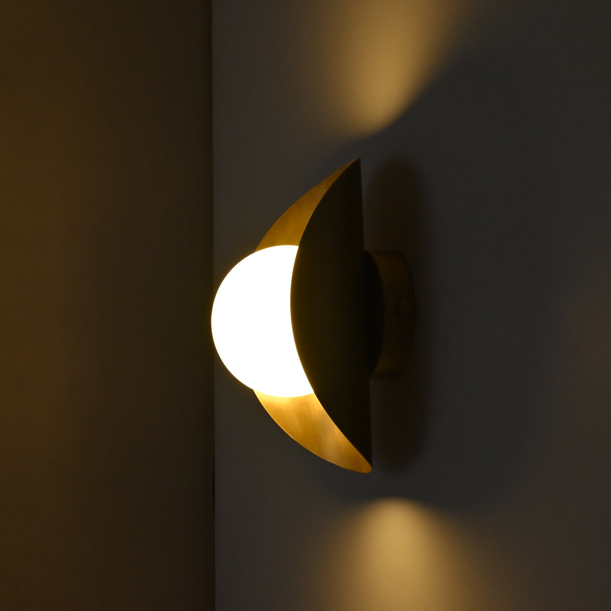 Opal globe wall light with curved brass shield and round wall canopy shown from side angle