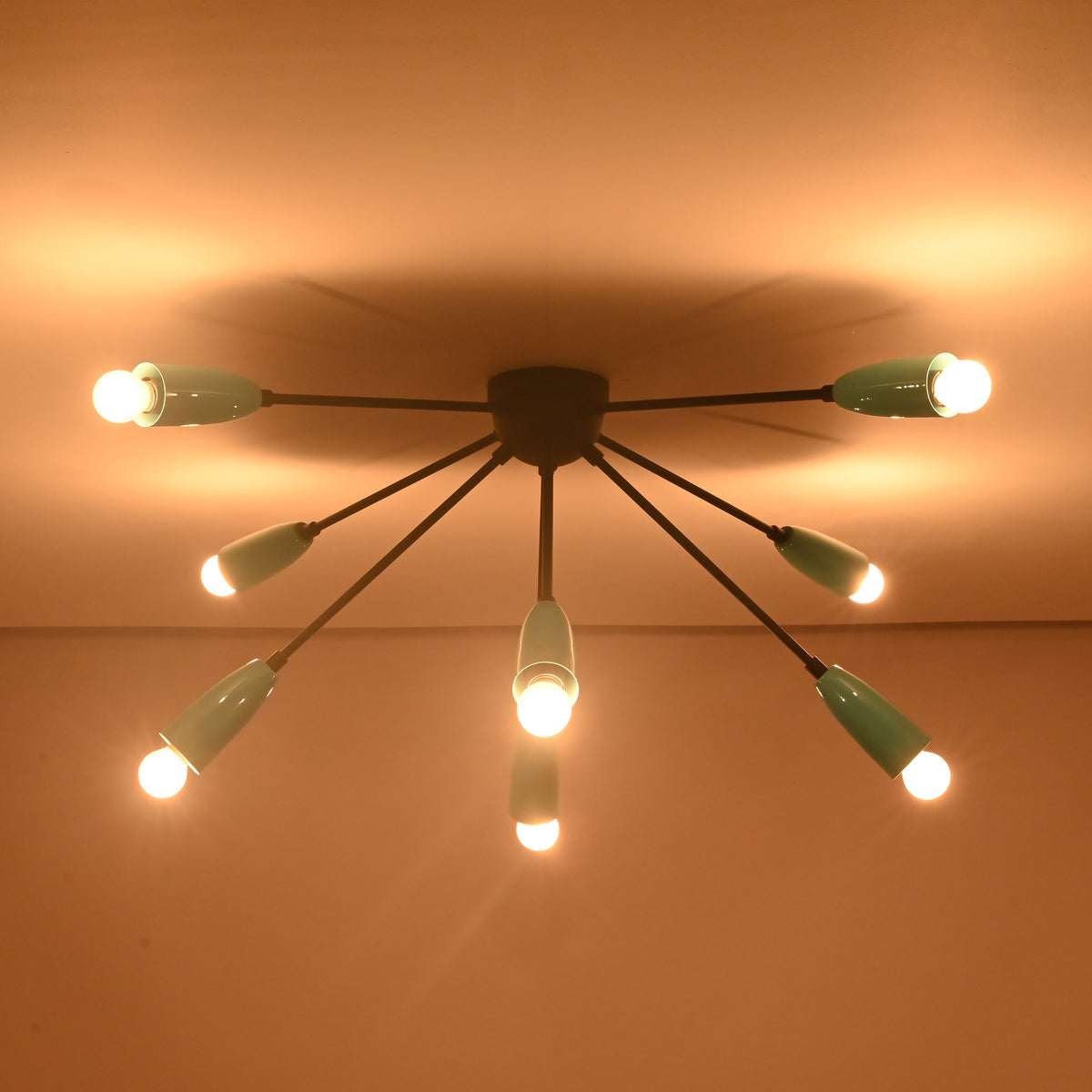 Indirect ceiling illumination from orbit brass flush mount light with eight exposed bulbs