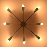 Orbit-style brass flush mount chandelier casting warm ambient light across the ceiling