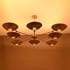Angled perspective of 8-arm brass chandelier with modern bowl discs and sleek drop rod