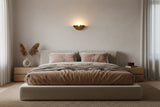Palermo brass sconce shown lit with warm golden glow reflecting beautifully on the wall