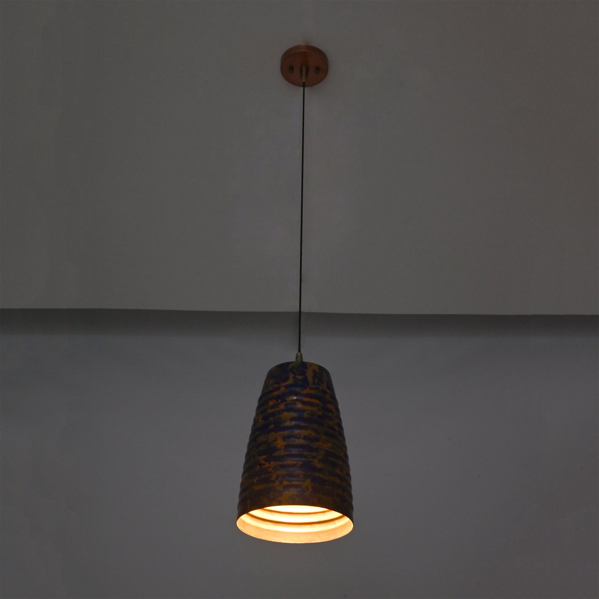Patina cylinder pendant light closeup highlighting the ribbed shade texture and decorative blue copper finish