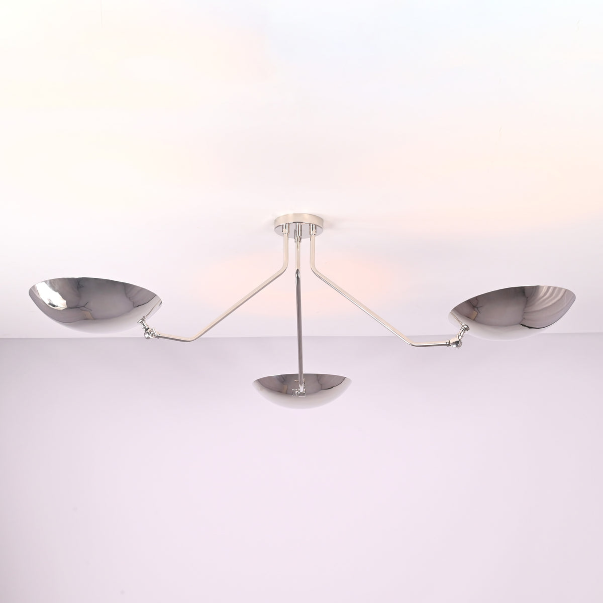 Close detail of polished chrome brass bowl shades on a modern semi flush mount ceiling light.