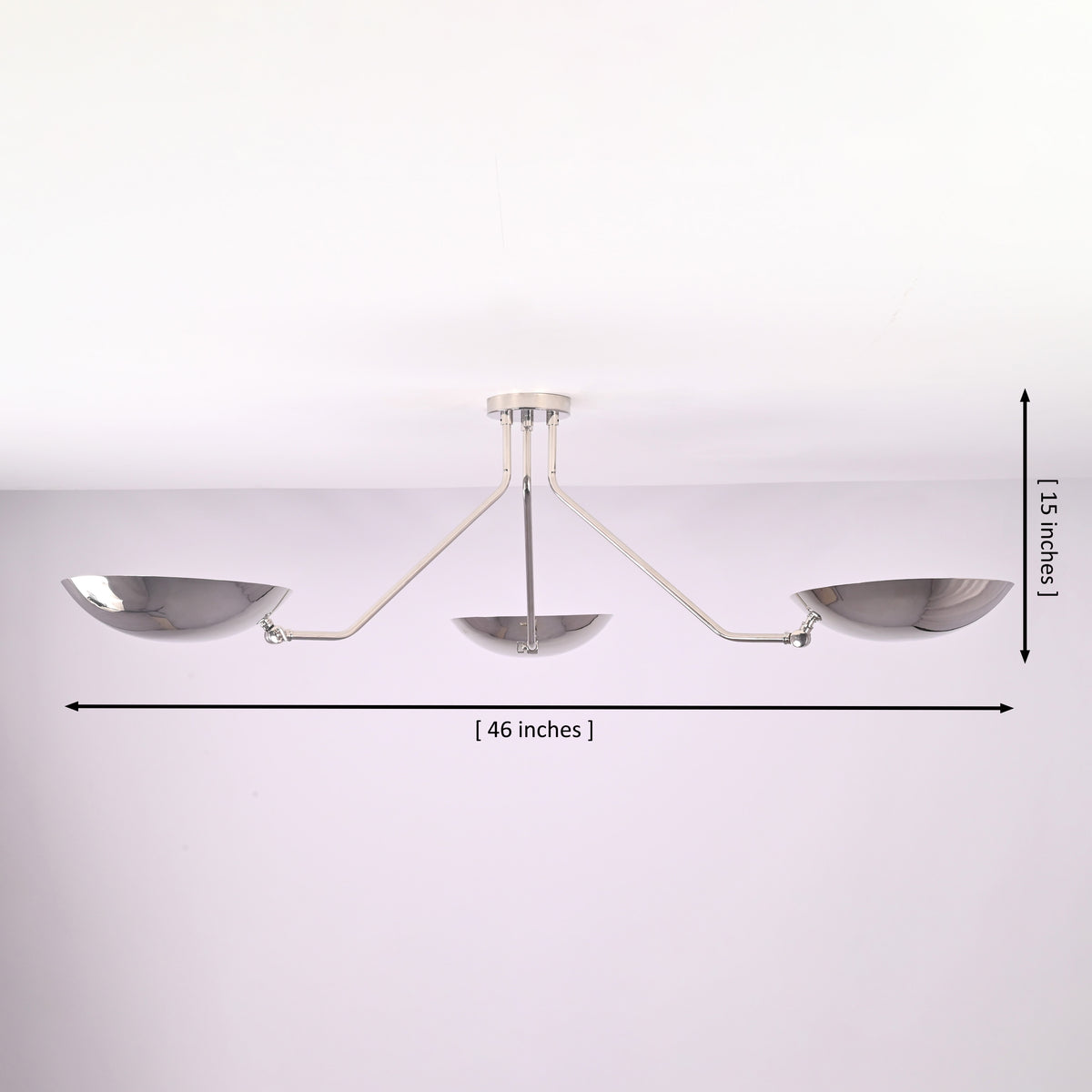Modern polished chrome ceiling light showing 46 inch width and 15 inch height with three bowl shaped brass shades.