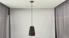 Video showing four ribbed blue and copper pendant lights installed above a dining table with black cords, copper canopies, warm downward glow, and luxury interior styling