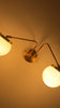 Customizable double globe wall sconce video showing two softly glowing opal shades, angled arms, and modern wall-mounted design