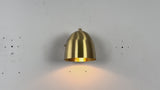 Close-up video of brass dome wall light highlighting rounded shade, backplate, and soft glowing effect.