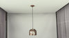 Video of Cora whitewashed copper drum pendant light showing warm glow, textured shade detail, black cord, and kitchen island installation