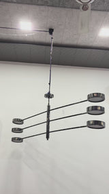 Madrid 6-light LED 3-arm pendant light video showing natural black brass finish, six round LED disc heads, wide linear arms, and bright downward illumination