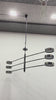 Madrid 6-light LED 3-arm pendant light video showing natural black brass finish, six round LED disc heads, wide linear arms, and bright downward illumination