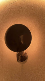 Brussels wall light video displaying the large curved disc shade, blackened brass finish and atmospheric glow from different angles