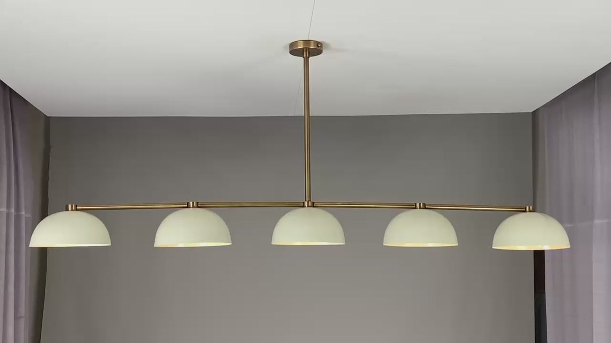 360° view of a modern 72-inch linear brass chandelier with five dome-shaped enamel shades, showcasing warm ambient lighting, minimalist silhouette, and sleek ceiling mount in various room settings.