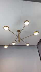 Athens 6-light linear disc chandelier video showing solid brass construction, six round disc light heads, warm downward glow, and modern ceiling-mounted installation