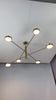 Athens 6-light linear disc chandelier video showing solid brass construction, six round disc light heads, warm downward glow, and modern ceiling-mounted installation