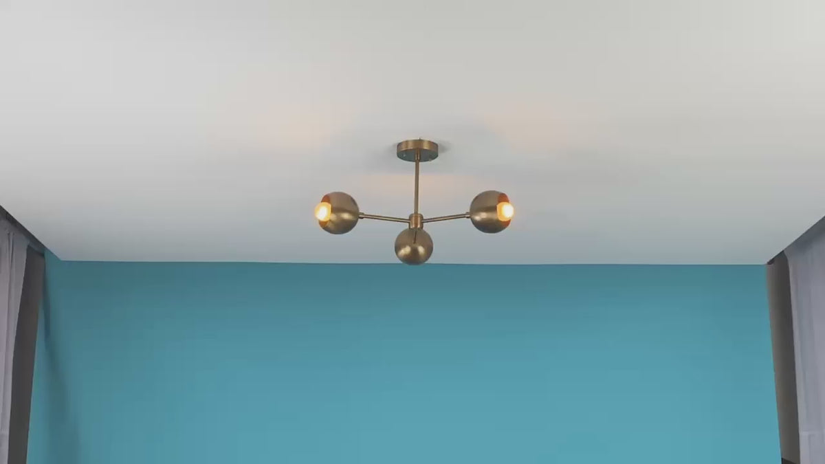 Video of handcrafted brass 3-light chandelier by Brass Leaf Studio – mid-century modern ceiling fixture with warm ambient glow, rotating view and lighting in action