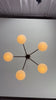 5-light oval glass ball chandelier video showing warm glowing opal shades, brass linear frame, and modern ceiling-mounted design