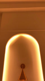Seville brass cone wall sconce video showing the lacquer coated patina finish, curved arm, round canopy and warm focused downward illumination