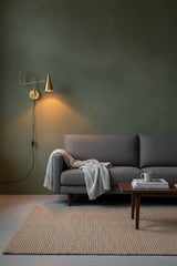 Raw brass bedroom reading wall light with adjustable swing arm and focused task lighting
