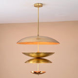 Handcrafted solid brass ceiling light with stacked bowl discs emitting a warm, ambient glow