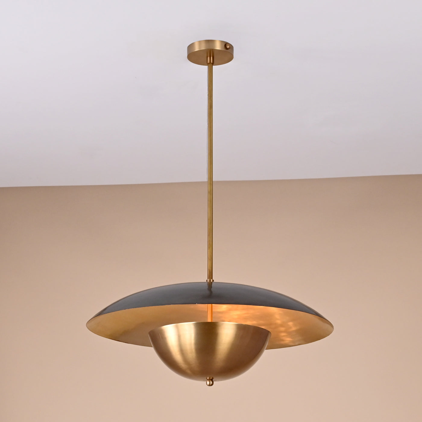 Handmade brass disc pendant light with dual dome design in raw and brushed brass finish against a neutral background