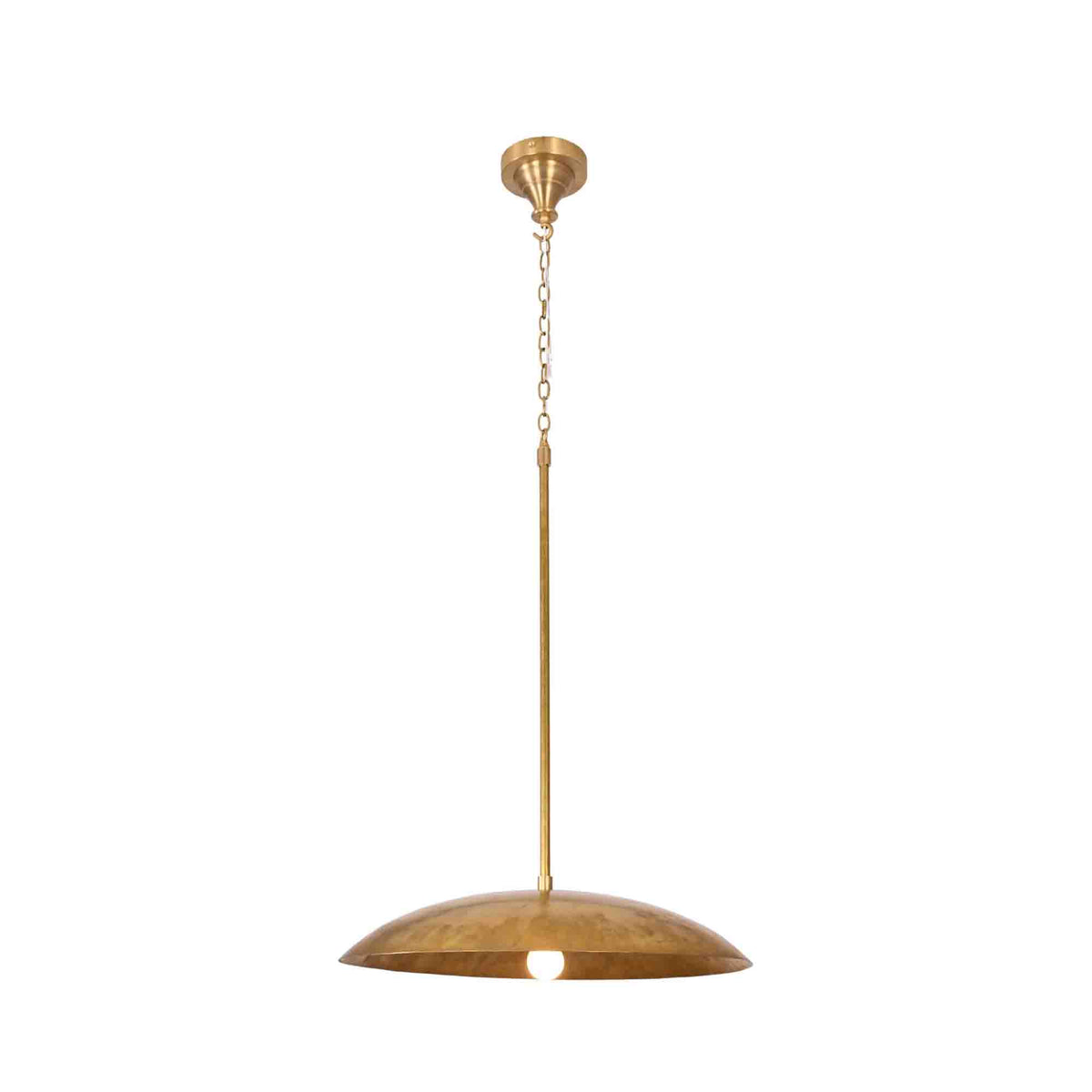 Raw brass dome pendant light closeup showing wide curved shade, chain suspension, and warm glowing bulb detail