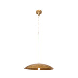 Raw brass dome pendant light closeup showing wide curved shade, chain suspension, and warm glowing bulb detail