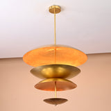 Elegant raw brass chandelier with three-tier disc design reflecting golden illumination