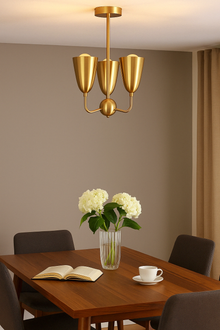 Front view of raw brass ceiling pendant with three cone-shaped shades in a flush mount layout