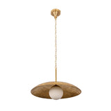 Closeup of raw brass pendant light showing natural surface character, dome disc shade, and soft opal globe