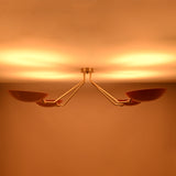 Top view of red disc flush mount ceiling light when lit, showcasing soft uplighting and balanced four light configuration.