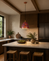 Colorful copper pendant light installed over a restaurant table with warm downward illumination and statement ceiling style