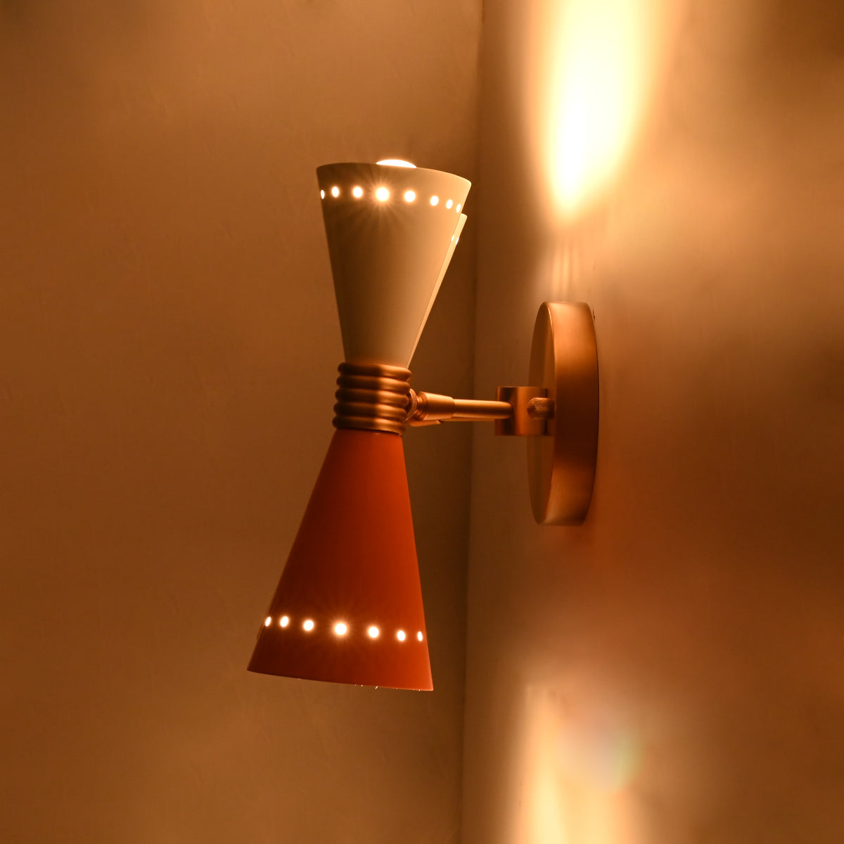 Retro solid brass wall lamp with two diabolo shades creating decorative upward and downward glow