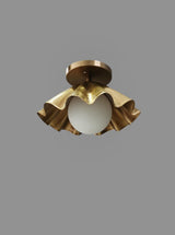 Closeup of handmade ruffled brass flushmount ceiling light, industrial modern design