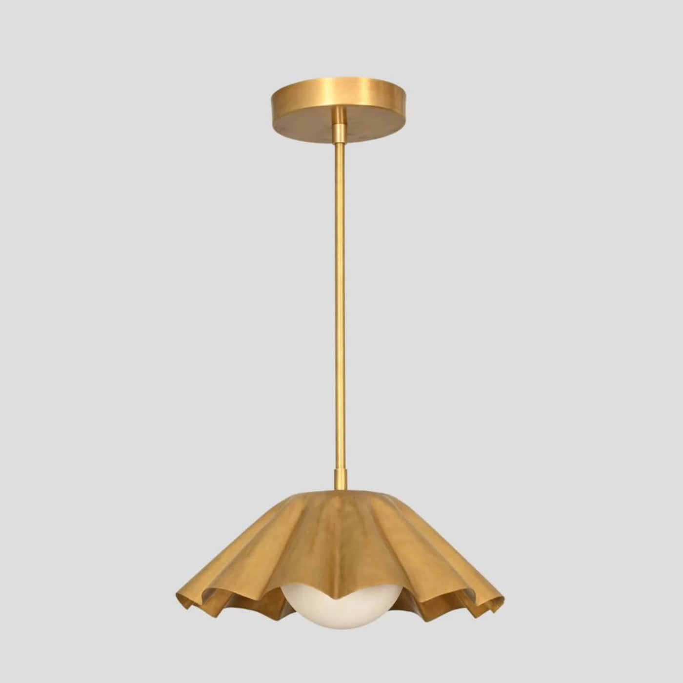 Handmade ruffled brass pendant light with sculptural dome shade and opal globe bulb, designed by Brass Leaf Studio for modern interiors.