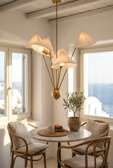 Close view of Santorini chandelier highlighting raw brass arms, central decorative body and fabric shades