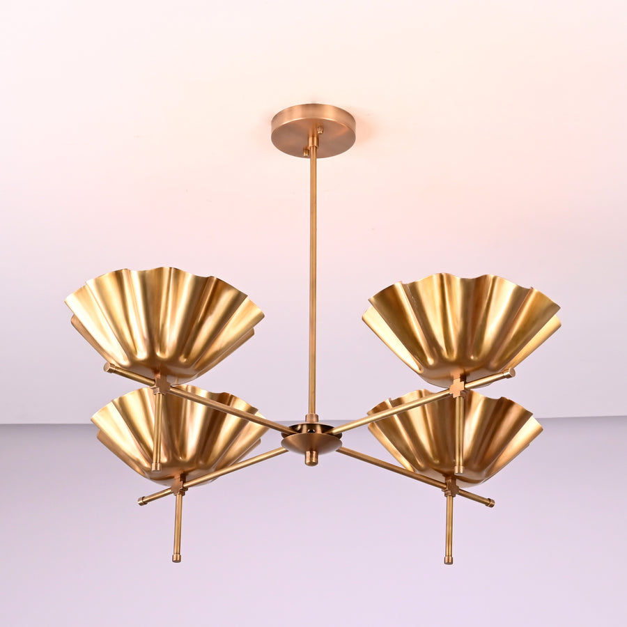 Modern brass chandelier with four sculpted scalloped bowl shades in a balanced minimalist design