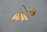 Handmade scalloped brass wall sconce with fluted shade and curved arm – side angle view