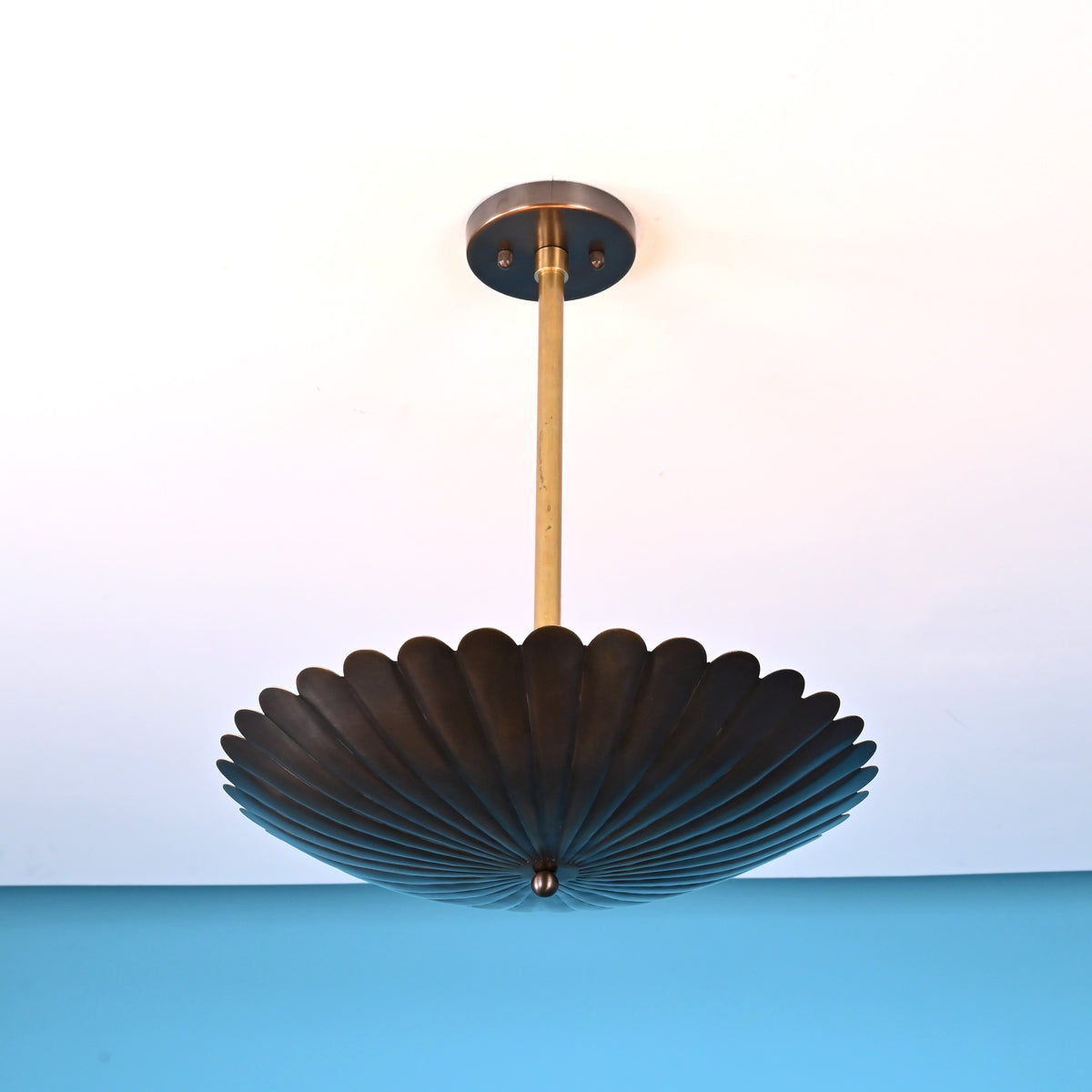 Bottom view of scalloped disc brass pendant light highlighting fluted bowl detailing