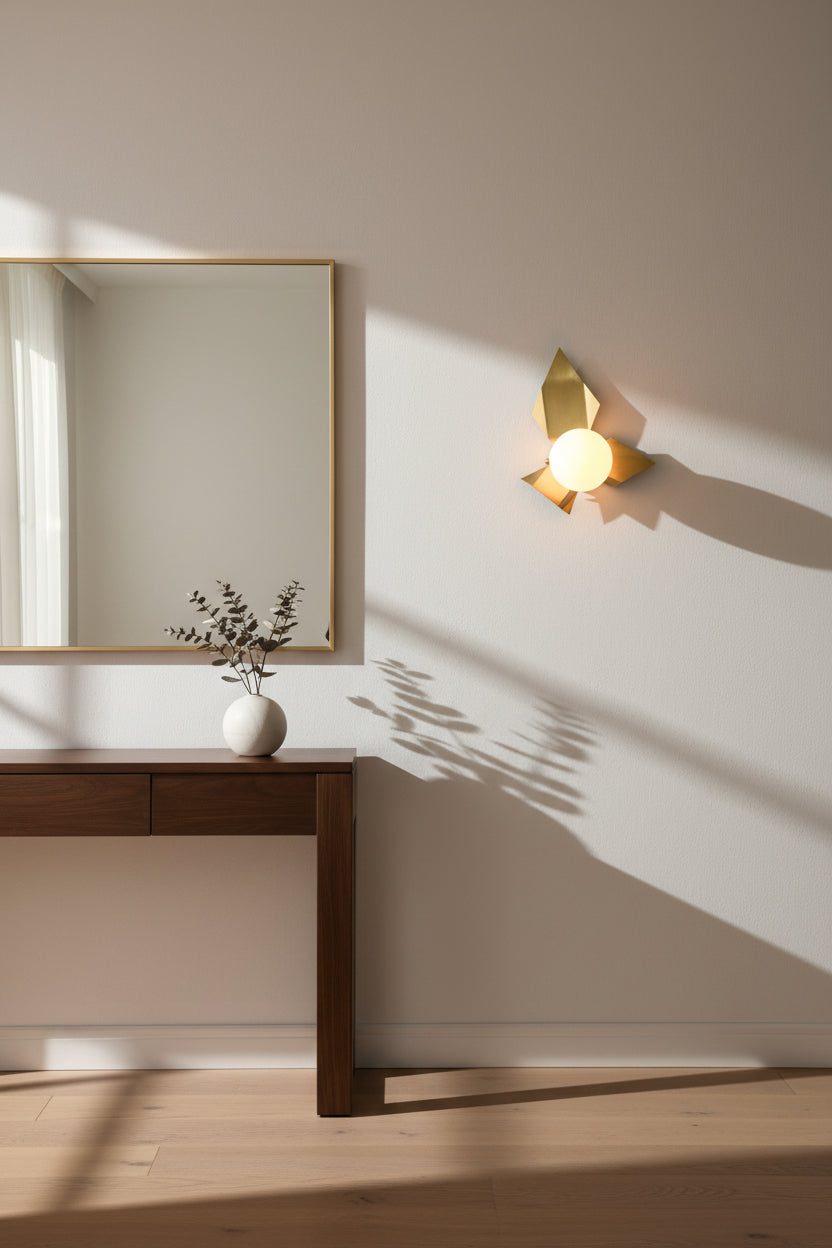 Sculptural brass globe wall light with leaf-inspired metalwork and round opal glass shade for accent lighting
