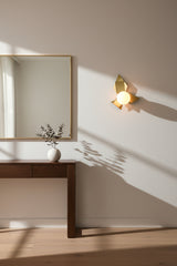 Sculptural brass globe wall light with leaf-inspired metalwork and round opal glass shade for accent lighting