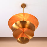 Bottom view of sculptural layered brass chandelier showcasing artistic disc arrangement and warm reflective surfaces.