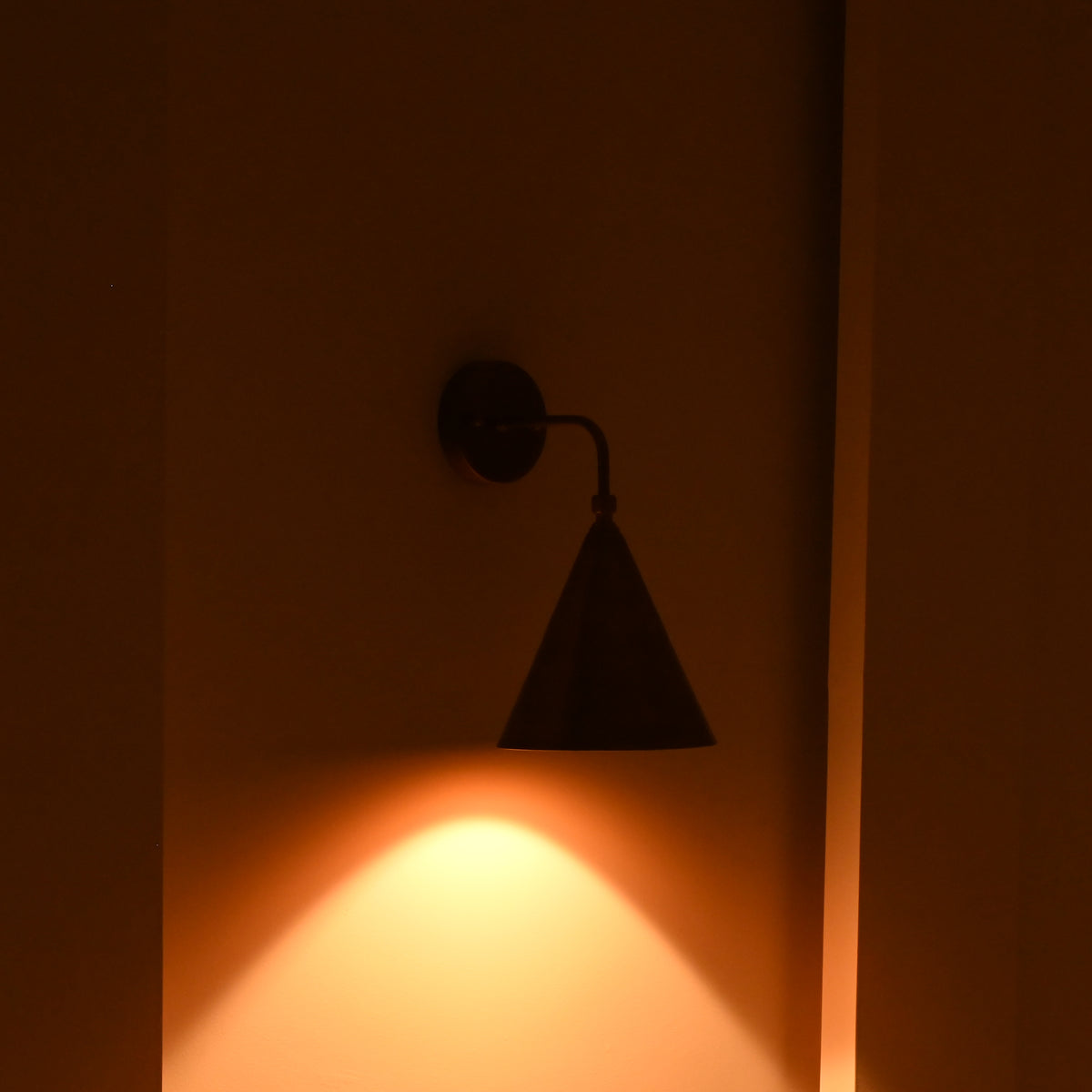 Customizable Seville brass wall sconce with cone shade, curved arm and warm architectural finish