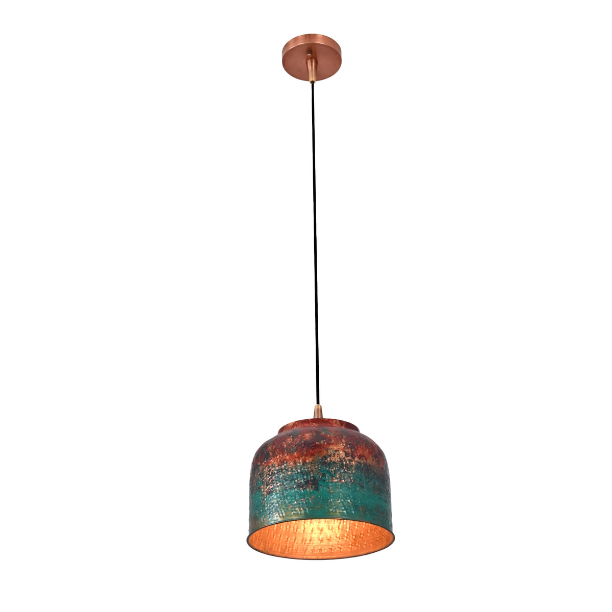 Single copper drum pendant light with black cord placed above a round dining table in a warm interior