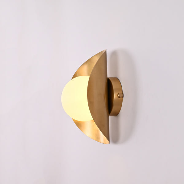 Solara crescent globe wall sconce shown in office interior with warm ambient wall glow
