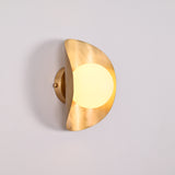 Solara globe wall light closeup showing warm diffused globe and sculptural crescent shield