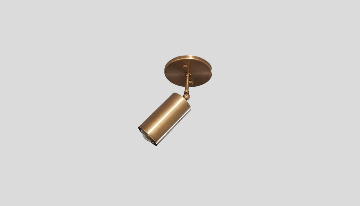 Angled view of adjustable solid brass spotlight ceiling light with brushed satin finish